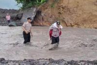 Foto/Dok : Personel Polsek Candipuro saat membantu siswa SD seberangi lahar Semeru. @sumber_RADAR9.ID/Kaperwil Jatim