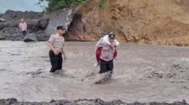 Foto/Dok : Personel Polsek Candipuro saat membantu siswa SD seberangi lahar Semeru. @sumber_RADAR9.ID/Kaperwil Jatim