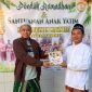 Foto: Dr. Naghfir menyerahkan bantuan buku kepada Pengasuh Yayasan Maqomam Mahmuda, Ustadz Yantoso Rema, S.Pd.I., di Desa Batuan, Kabupaten Sumenep, Jumat (13/3/2026). Bantuan tersebut diberikan sebagai upaya mendorong peningkatan budaya literasi di kalangan santri. Dokumentasi RADAR9.ID.