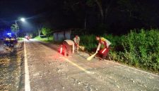 Foto: Dua anggota Polsek Manding bersama warga sigap membersihkan tumpahan batu cor yang berserakan di Jalan Raya Desa Jabaan, guna mencegah risiko kecelakaan. Dokumentasi RADAR9.ID/Redaksi.